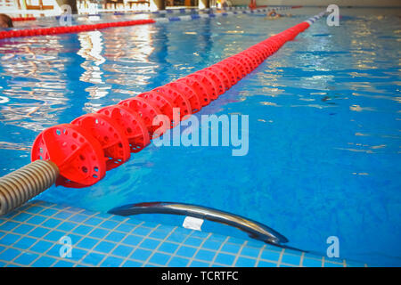 Die rot markierten Fahrstreifen für die Vorbereitung der Schwimmwettbewerbe. Lap Pool mit markierten Wege. Leeren Pool ohne Menschen mit ruhigen stehendes Wasser Stockfoto