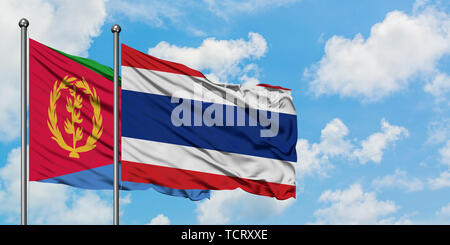 Eritrea und Thailand Flagge im Wind gegen Weiße bewölkt blauer Himmel zusammen. Diplomatie Konzept, internationale Beziehungen. Stockfoto