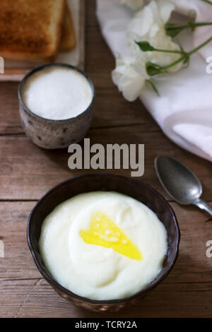 Hausgemachtes Frühstück von griess Porridge, Kaffee mit Milch und Toast auf einem hölzernen Hintergrund. Rustikaler Stil, selektiven Fokus. Stockfoto