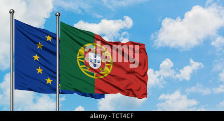 Der Europäischen Union und Portugal Flagge im Wind gegen Weiße bewölkt blauer Himmel zusammen. Diplomatie Konzept, internationale Beziehungen. Stockfoto