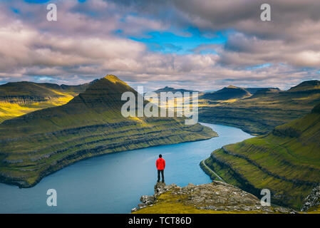 Wanderer mit Blick auf den fjorden von einem Berg in der Nähe von Funningur auf den Färöer Inseln Stockfoto