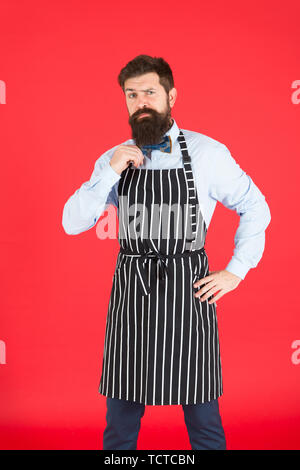Arbeit Süchtiger. Hipster tragen elegante Arbeit einheitlich. Koch oder Barkeeper routinemäßige Arbeit in Restaurant Bar oder in der Küche. Bärtiger Mann in Bow Tie und Schürze. Tägliche Arbeitsabläufe und Aktivitäten. Stockfoto