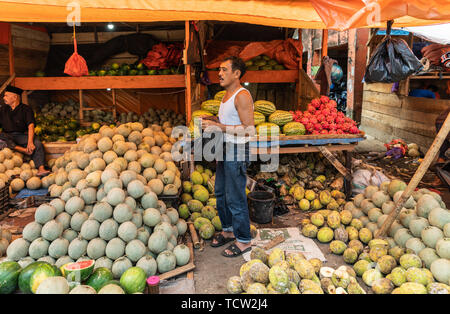 Makassar, Sulawesi, Indonesien - 28. Februar 2019: Terong Street Market. Obst stand bietet Haufen verschiedener Arten, Kugel Groß und Klein unter Stockfoto