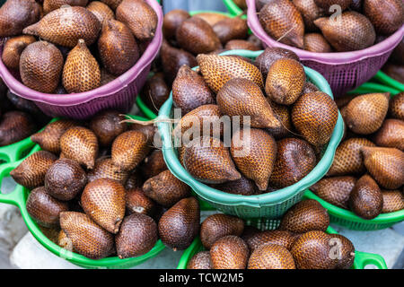 Makassar, Sulawesi, Indonesien - 28. Februar 2019: Terong Street Market. Nahaufnahme von Grün und Violett Körbe mit Brown snake Früchten gefüllt. Stockfoto