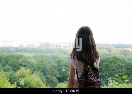 Junge Mädchen für Reisende mit einem kleinen Rucksack, und genießen Sie den atemberaubenden Blick auf die Stadt, Wandern und Ausflüge in die Natur. Erwartung. Stockfoto