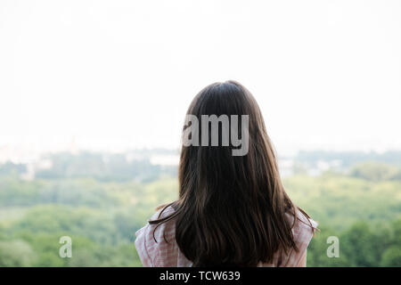 Junge Mädchen für Reisende mit einem kleinen Rucksack, und genießen Sie den atemberaubenden Blick auf die Stadt, Wandern und Ausflüge in die Natur. Erwartung Stockfoto