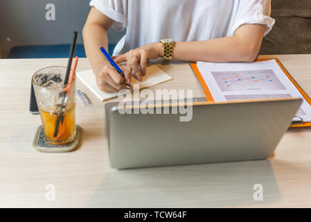 Nahaufnahme der menschlichen Hand schreiben auf Notebook bei der Arbeit Stockfoto
