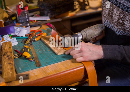 Skinner arbeiten mit Leder Gürtel Stockfoto