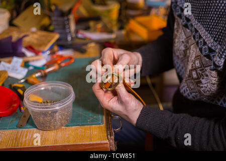 Skinner arbeiten mit Leder Gürtel Stockfoto