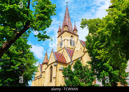 Lutherische Kathedrale der Heiligen Maria (Catedrala Evanghelica C.A. Sfanta Maria) in Sibiu, Rumänien, Blick auf den Aussichtsturm, von grünen Bäumen umrahmt, ich Stockfoto