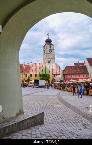 Sibiu, Rumänien - 27. Mai, 2019: Der Rat Turm (Turnul Sfatului) unter einer Passage arch der Künste Haus - Metzger Guild Hall in Hermannstadt gesehen, Romani Stockfoto