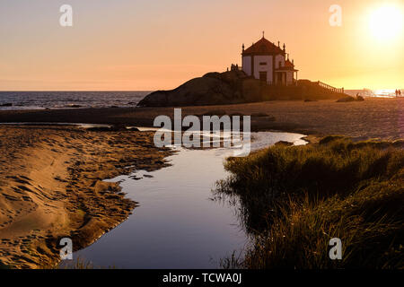 Vila Nova de Gaia, Portugal - Juni 09, 2019: Fluss auf dem Weg zum Meer, Kapelle auf den Felsen bei Sonnenuntergang, Porto district, Portugal Stockfoto