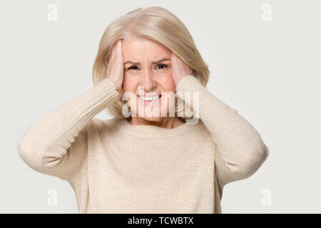 Reife Frau mit Kopf in den Händen fühlt sich ungesunde Studio shot Stockfoto