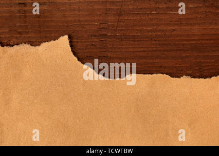 Ein overhead Foto zerrissenen braun Kraftpapier auf einem dunklen Holzmöbeln im Landhausstil Hintergrund, eine Grunge design Vorlage mit Kopie Raum Stockfoto