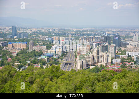 Panoramablick auf die Stadt Almaty, mit Industrial Zone, die Berge und den Himmel mit Wolken. Von Kok Tobe, Kasachstan gesehen. Stockfoto