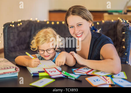 Ein Lehrer, ein Tutor für heimunterricht und ein Lehrer am Tisch. Oder Mutter und Tochter. Homeschooling Stockfoto