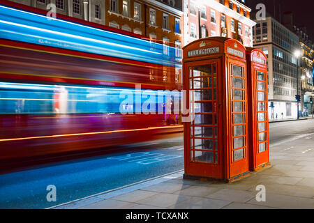 Leichte Spuren eines Double Decker Bus neben dem ikonischen Telefonzelle in London Stockfoto