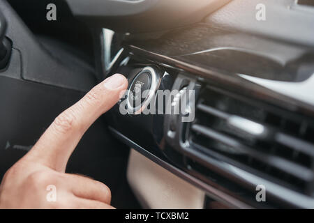 Das Anlassen des Motors. 7/8 Bild einer Hand Druck auf den START- und STOP-Taste des Auto Motor. Treiber Hand. Probefahrt Stockfoto