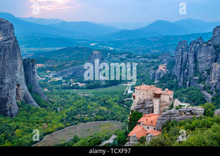 Blick auf die Felsen von Meteora mit Kloster Roussanou und St. Nikolaus Anapausas nach Sonnenuntergang. Meteora, Ebene von Thessalien, Griechenland Stockfoto
