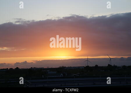 Sonnenstrahlen hinter Wolken bei Sonnenuntergang in bunten Himmel bei Moordrecht Stockfoto