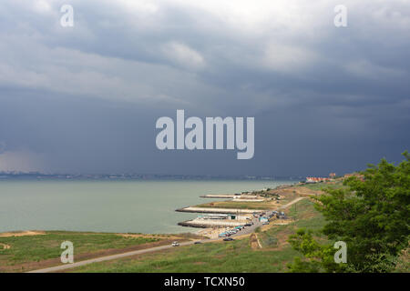 Sturmwolken über das Meer und die Stadt. Dorf an der Küste Liski. Region Odessa. Die Ukraine Stockfoto