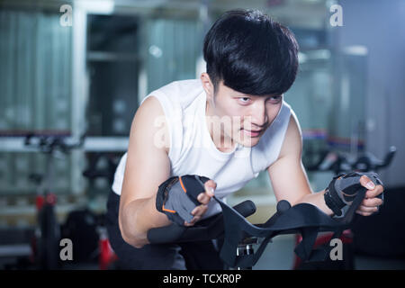 Die Jungen gut aussehenden asiatischer Mann arbeitet in modernen gynm Stockfoto