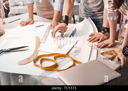 Konzept der neuen Design. Close-up sind eine Gruppe von Designern denken über neue Kleid. Produkte maßgeschneidert sind am Tisch. Schere, Maßband, ruller, string Stockfoto