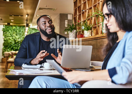 Freundliche Kollegen gute Beziehungen, angenehme Unterhaltung im Restaurant während der Kaffeepause, lächelnden jungen Frau hören gesprächig Co-worker Stockfoto