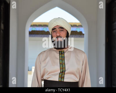 Kokand, Fergana-tal, Usbekistan - 4. JUNI 2019: Portrait des usbekischen Mann, gekleidet in die traditionellen Turban, in der Tür der Pa Stockfoto