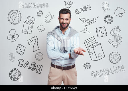 In seinem Glück zuversichtlich. Charmante bärtiger Mann mit einem blauen Hemd lächelt in die Kamera während gegen grauen Hintergrund stehen mit unterschiedlichen Doodle illustra Stockfoto