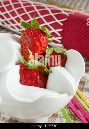 Schale mit roten Erdbeeren auf weiche, weiße Milch creram Stockfoto