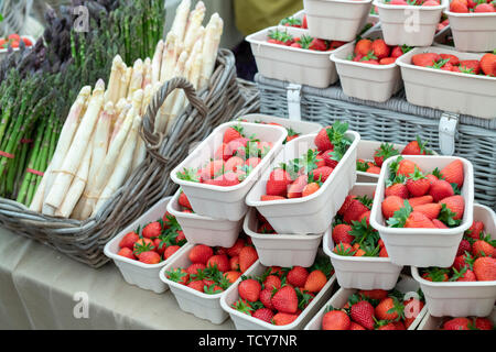 Fragaria × ananassa. Körbchen mit frischen Erdbeeren und Spargel für Verkauf bei Daylesford Organic Farm Sommer Festival. Daylesford, Cotswolds, Großbritannien Stockfoto