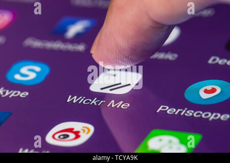 Finger, mit dem Wickr mir Symbol in die App auf einem Touchscreen auf einem Smartphone oder Tablet mobile Gerät zu laden. Stockfoto