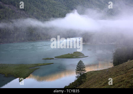 In Kanas See, Xinjiang, im August 2018, am frühen Morgen unsterblich Bay, Wolken und Nebel fotografiert. Stockfoto