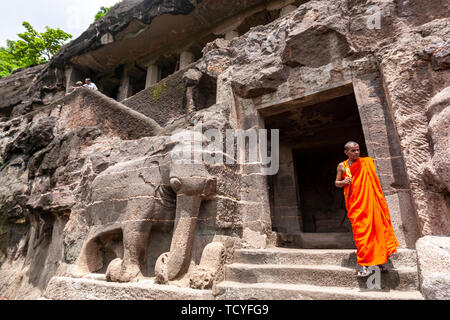Buddhistischer Mönch im Eingang Treppe in das einstöckige Cave 16, mit Stein Elefanten, Ajanta Höhlen, Mumbai, Maharashtra, Indien Stockfoto