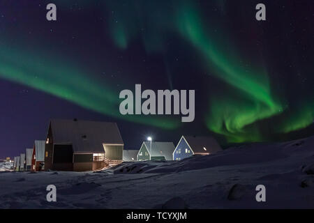 Arctic Village und grünen Wellen von Northern Lights über Inuit Häuser, in einem Vorort von Nuuk, Grönland Stockfoto