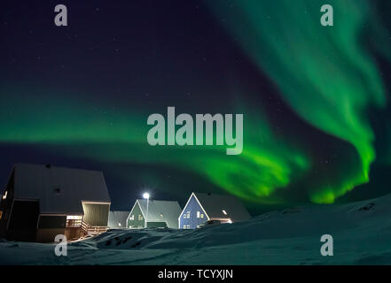 Arctic Village und grünen Wellen von Northern Lights über Inuit Häuser, in einem Vorort von Nuuk, Grönland Stockfoto