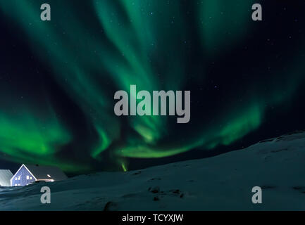 Arctic Village und grünen Wellen von Northern Lights über Inuit Häuser, in einem Vorort von Nuuk, Grönland Stockfoto