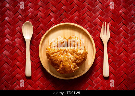 Ansicht von oben Croissants auf hölzernen Schale mit Löffel und Gabel auf Textur aus geflochtenem Bambus. Stockfoto