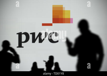 Die PWC-Logo ist auf dem LED-Bildschirm im Hintergrund, während eine Silhouette Person ein Smartphone verwendet im Vordergrund (nur redaktionelle Nutzung) Stockfoto