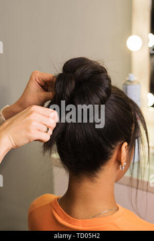 Haarstilist Hände fix hohe Bündel Haare. Lernen zu einem Abend Frisur erstellen. Friseursalons workshop Stockfoto