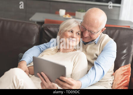 Senior Paar mit digitalen Tablette zu Hause. Großeltern mit Social Media. Stockfoto
