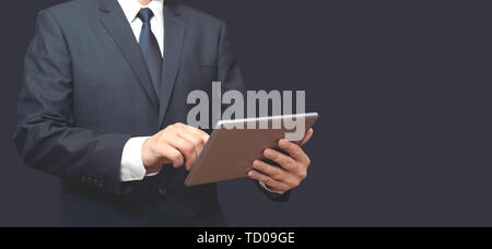 Mann mit digitalen Tablet in der Hand. Nicht erkennbare Person im Anzug, Kopie Raum breite Bild für Banner. Stockfoto