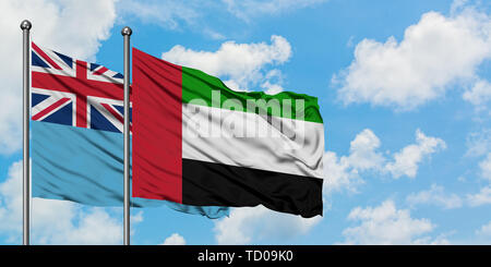 Fidschi und die Vereinigten Arabischen Emirate Flagge im Wind gegen Weiße bewölkt blauer Himmel zusammen. Diplomatie Konzept, internationale Beziehungen. Stockfoto