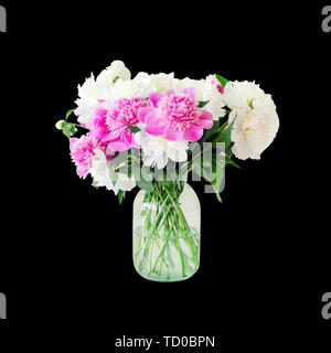 Blumenstrauß aus frischen Big Pink, Weiß und Creme Pfingstrosen in einfachen Glas Glas auf Blick Tabelle innen isoliert auf Schwarz. Vase mit wunderschönen zarten Feder Stockfoto