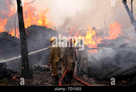 Jammu, Indisch kontrollierten Teil Kaschmirs. 11 Juni, 2019. Die Feuerwehr einen Brand, der in einem Holz godown in Jammu, der Winter, die Hauptstadt der Indischen kontrollierten Kaschmir, Juni 11, 2019 brach löschen. Credit: Stringer/Xinhua/Alamy leben Nachrichten Stockfoto