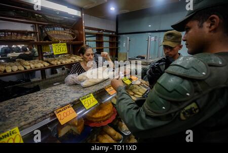 05. Juni 2019, Venezuela, Caracas: Soldaten kaufen Brot im 'La Minka, eine Bäckerei, die von Anhängern der Regierung. Die ehemalige private Bäckerei war 'Mansion Bäckerei' genannt. Jetzt rund 6.000 Stücke Brot gibt es jeden Tag bei der Preise durch den Staat produziert. Das Land mit den größten Ölreserven der Welt befindet sich in einem dramatischen Niedergang. Geld Abwertung ist die höchste in der Welt, für viele Menschen essen ist unbezahlbar. Diese 'Bäckereien Bolivarischen', das Brot zu festen Preisen verkaufen, sehen ihre Aufgabe als Teil der "Sozialismus des 21. Jahrhunderts" ausgerufen, die von der späten Staatschef Hugo Chavez. Phot Stockfoto