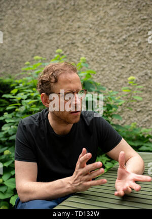 06 Juni 2019, Deutschland (Deutsch), Berlin: Galerist Johann König sitzt an einem Tisch. Als erfolgreicher Galerist, die er auf der Liste der hundert einflussreichsten Menschen in der zeitgenössischen Kunst. Nur sieht er kaum. König ist fast blind. (Zu "Bilder im Kopf" - Johann Königs Erfolg als "Blinder Galerist'') Foto: Theresa Kottas-Heldenberg/dpa Stockfoto