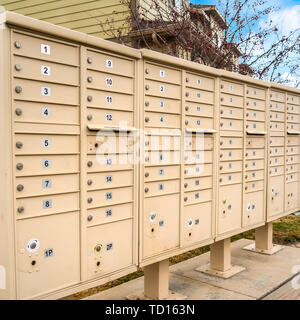 Qm Wohn- Mailboxen mit nummerierten Fächern auf der Seite einer Straße Stockfoto