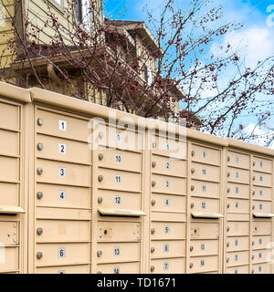 Quadratischen rahmen Wohn- Mailboxen mit nummerierten Fächern auf der Seite einer Straße Stockfoto